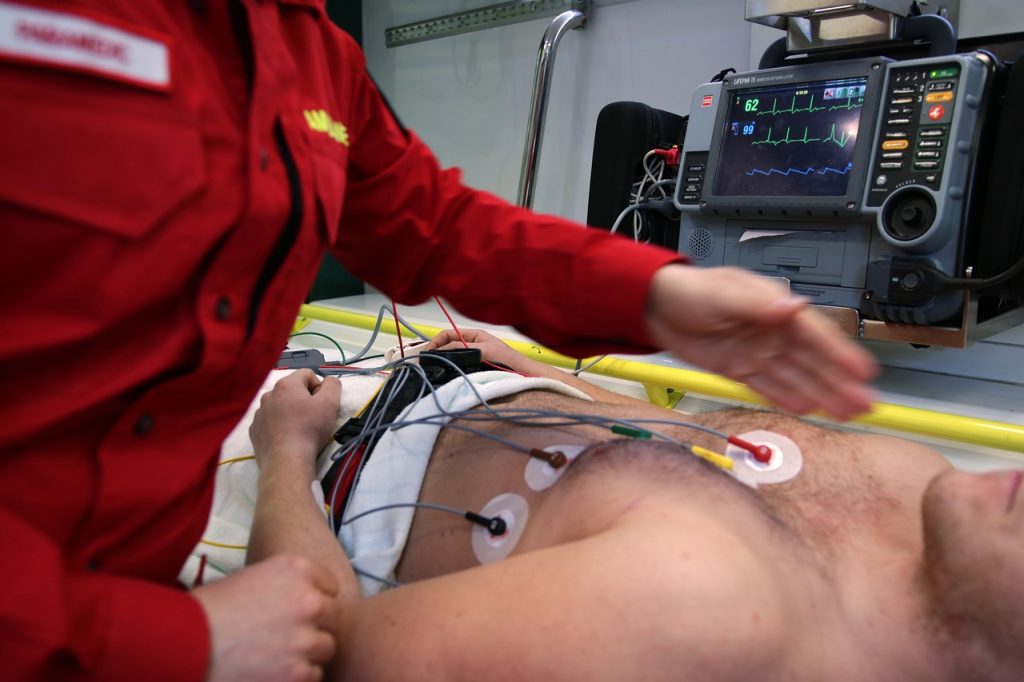 a medic standing over a man on a stretcher